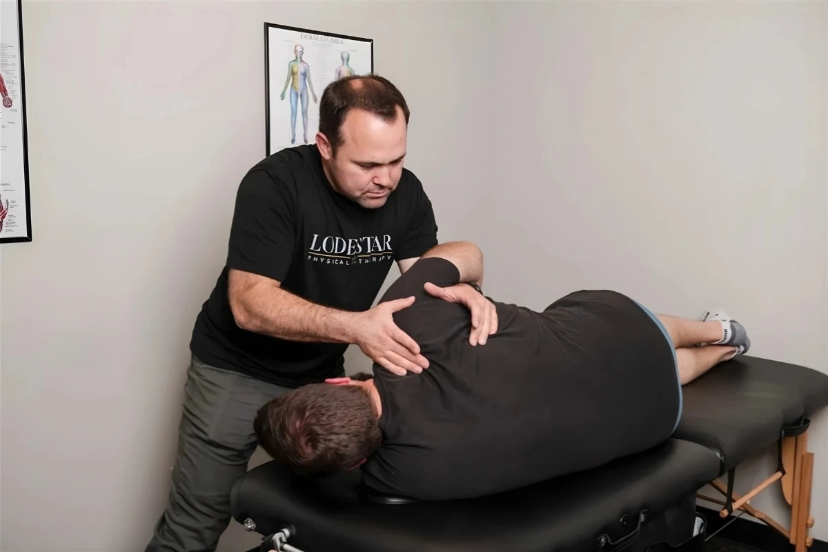 Physical therapist guiding a patient through a hands-on treatment session